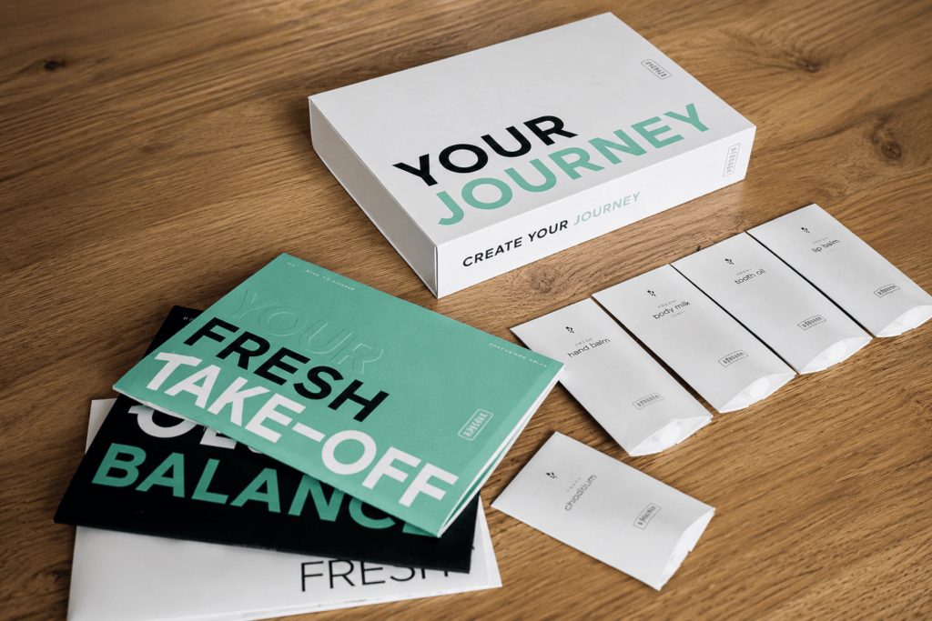 RINGANA Partner werden, die RINGANA Starter Unterlagen sowie Fresh Take off liegen auf einem Holztisch.